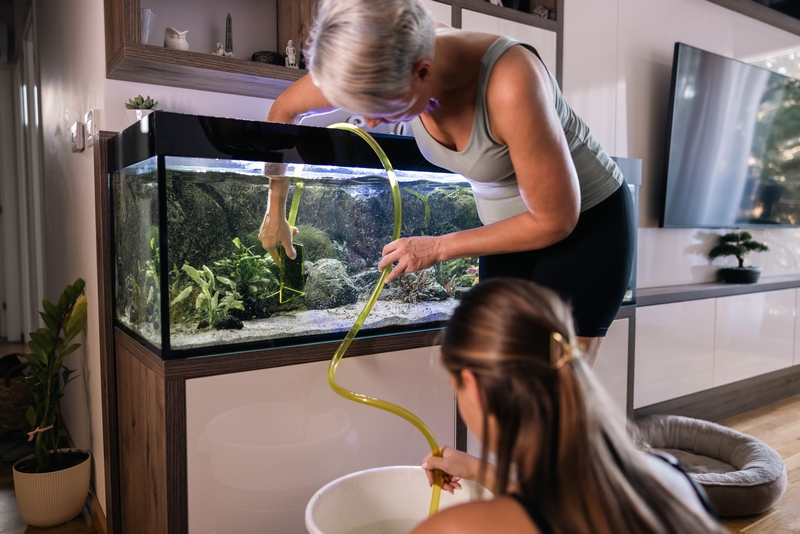 femme et sa fille qui nettoient un aquarium